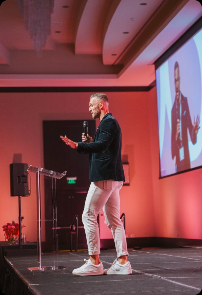 Wade Critides speaking on stage